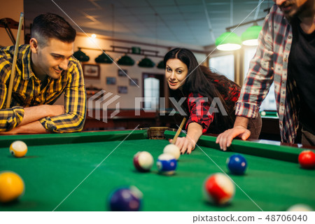 Billiard players with cues at the table with balls 48706040