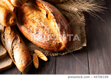 Rustic bread roll or french baguette, wheat and flour on wooden. Rural kitchen or bakery - 48706199