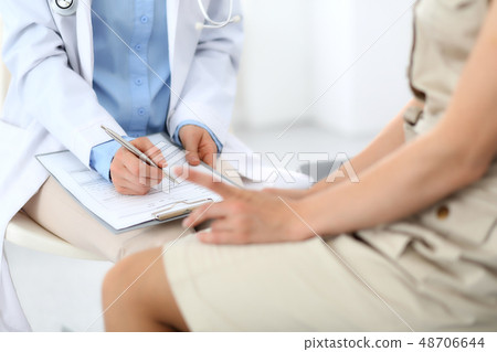 Doctor and patient talking. Physician at work in hospital while writing up medication history 48706644