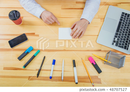 Office table with accessories: white paper, blue and pink marker, black phone, coffee cup, pen Office table with accessories: white paper, blue and pink marker, black phone, coffee cup, pen 48707527