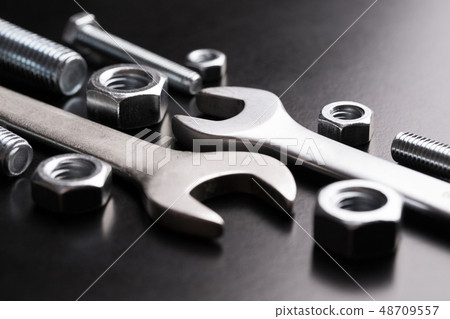 Nuts and wrench bolts on a dark background Nuts and wrench bolts on a dark background 48709557