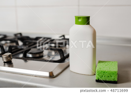 Cleaning product in plastic bottle at gas stove. Cleaning product in plastic bottle at gas stove. 48711699