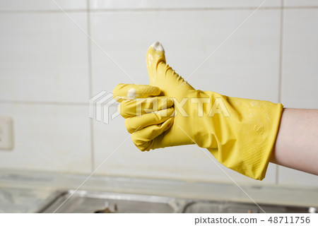Female hand in yellow glove showing thumb up 48711756