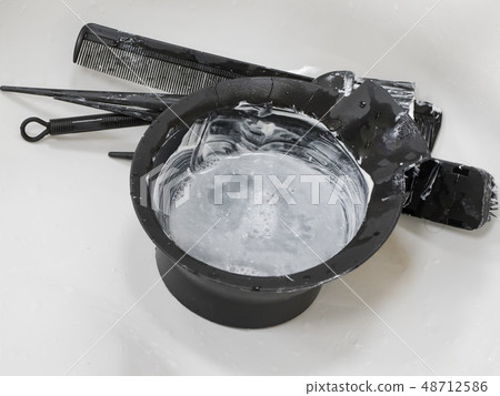 Dirty bowl for mixing hair dye in the sink. Dirty bowl for mixing hair dye in the sink. 48712586