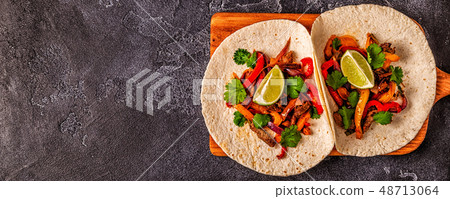 FAJITAS with colored pepper and onions, served FAJITAS with colored pepper and onions, served 48713064