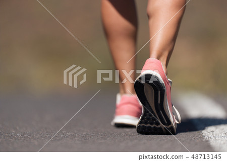 Running shoe closeup of woman running on road Running shoe closeup of woman running on road 48713145