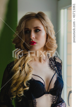 Close-up portrait of sexy blonde woman in black negligee 48713861