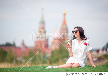 Happy young urban woman drinking coffee in european city. Happy young urban woman drinking coffee in european city. 48713874