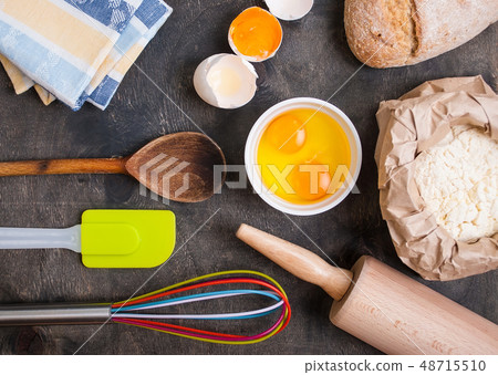 Baking kitchen utensils on vintage planked wood table from above 48715510