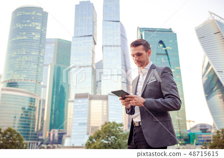 Young caucasian man holding smartphone for business work. Young caucasian man holding smartphone for business work. 48715615