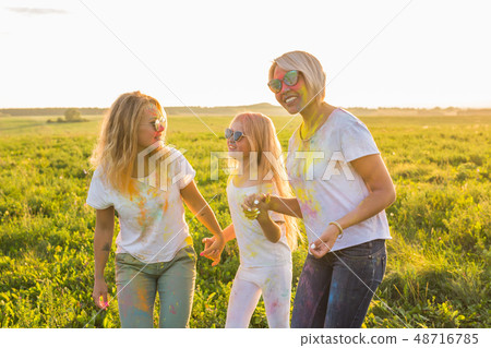 Festival of holi, people concept - Group of young people having fun outdoors Festival of holi, people concept - Group of young people having fun outdoors 48716785