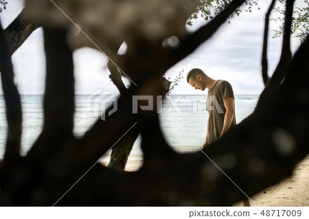 Handsome guy stands on tropical sand beach Handsome guy stands on tropical sand beach 48717009