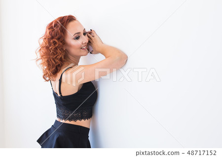 People and fashion concept - Redhead woman in black shirt and skirt posing isolated on white People and fashion concept - Redhead woman in black shirt and skirt posing isolated on white 48717152