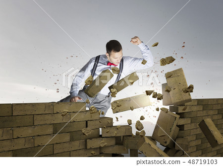 Businessman crashing bricks Businessman crashing bricks 48719103