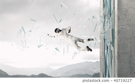 Woman breaking through glass Woman breaking through glass 48719227