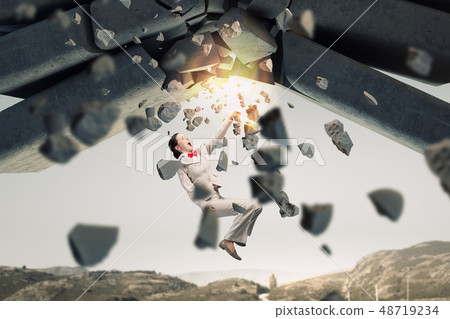 Businesswoman crashing bricks Businesswoman crashing bricks 48719234
