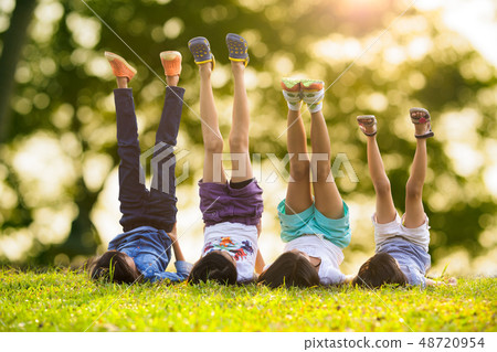 Children laying on grass Children laying on grass 48720954
