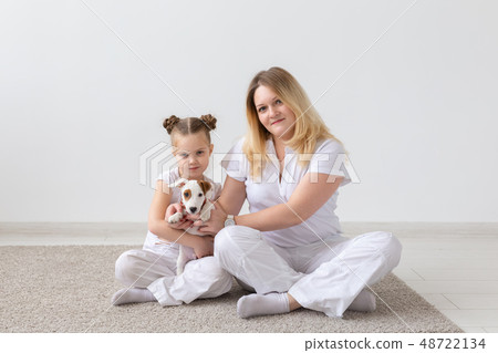 people, family and pets concept - mother and daughter sitting on the floor with puppy Jack Russell people, family and pets concept - mother and daughter sitting on the floor with puppy Jack Russell 48722134