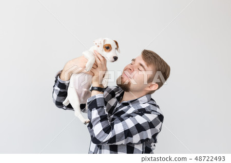 People and pet concept - Close up portrait of jack russell terrier puppy sitting on the man's hands 48722493