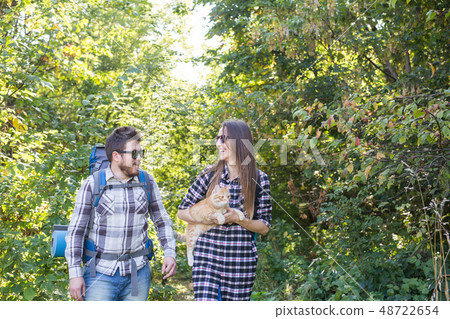 Travel, adventures, hike, tourism and nature concept - Tourist couple with cat walking in the woods 48722654