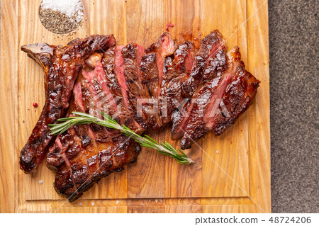 food, delicious and craft concept - cutting horse meat steak on wooden desk 48724206