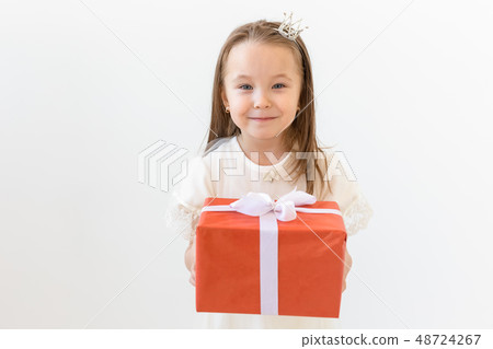 people, children and holiday concept - portrait of happy little girl holding a gift box over white people, children and holiday concept - portrait of happy little girl holding a gift box over white 48724267