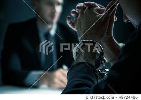 Criminal man with handcuffs in interrogation room Criminal man with handcuffs in interrogation room 48724480