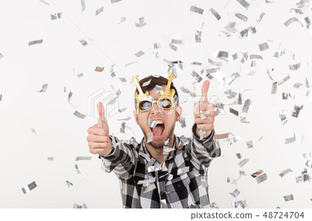 People, holidays and party concept - Man with funny face in plaid shirt with confetti 48724704