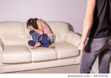 Domestic violence and abuse concept - man threatening with fist to crying woman 48724792