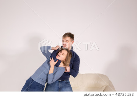 people, abuse and violence concept - agressive man strangling his wife people, abuse and violence concept - agressive man strangling his wife 48725188