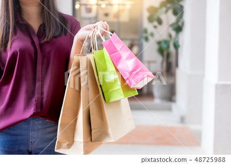 Woman look at mobile phone with paperbags in the Woman look at mobile phone with paperbags in the 48725988