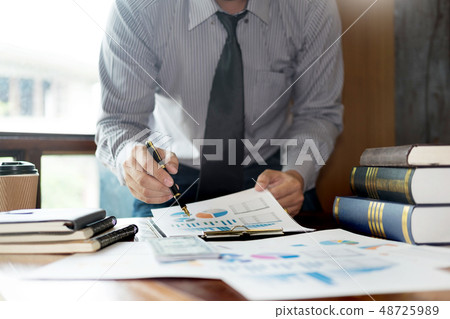 Casual businessman sitting at his desk online Casual businessman sitting at his desk online 48725989