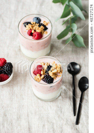 Yogurt with berries and granola in glass cup Yogurt with berries and granola in glass cup 48727174