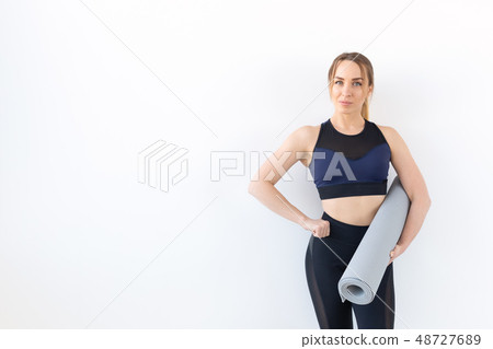 People, fitness and sport concept - Attractive and healthy woman holding grey mat over white People, fitness and sport concept - Attractive and healthy woman holding grey mat over white 48727689