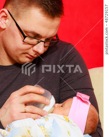 father feeding newborn baby girl with milk bottle father feeding newborn baby girl with milk bottle 48729157