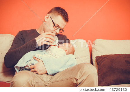 Father feeding from bottle newborn baby Father feeding from bottle newborn baby 48729180