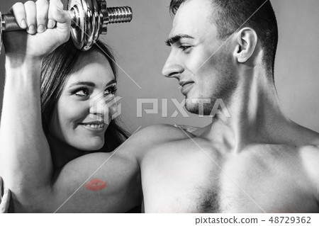 Couple muscular man and girl admiring his strength. 48729362