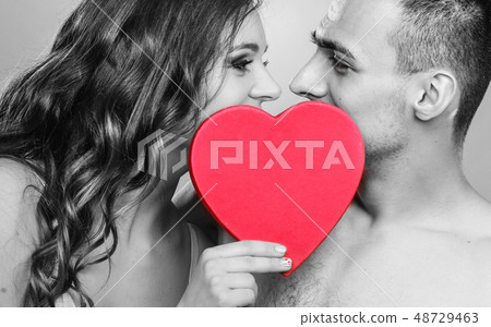 romantic couple kissing behind red heart 48729463