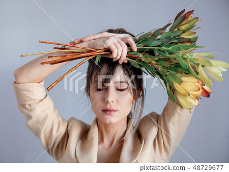 Young woman with bouquet of  Leucadendron 48729677