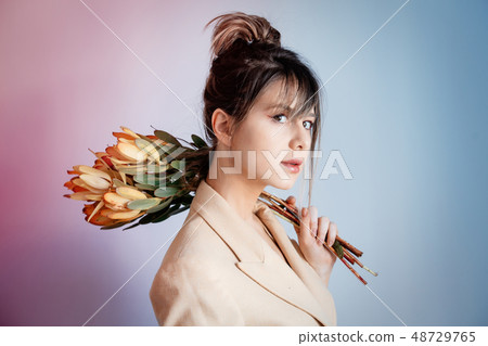 Young woman with bouquet of  Leucadendron 48729765