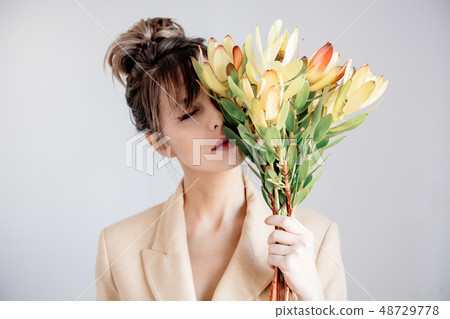 Young woman with bouquet of  Leucadendron 48729778