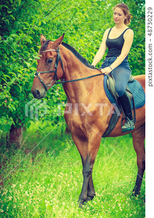 Young woman sitting on a horse 48730229