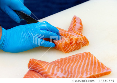 chef slicing raw fresh salmon, Chef preparing a 48730775