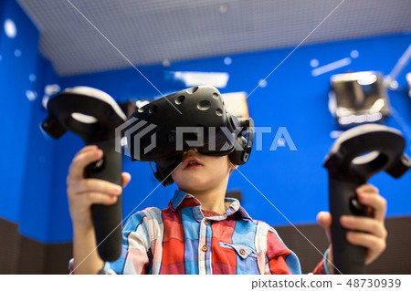 modern technology, gaming and people concept - boy in virtual reality headset or 3d glasses playing 48730939