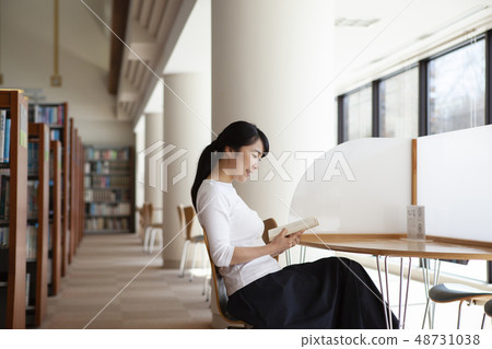 A woman reading in a library 48731038