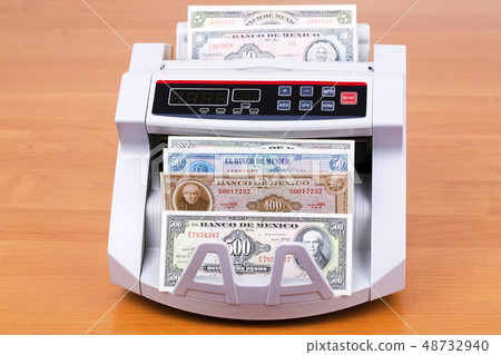Old Mexican Peso in a counting machine  48732940