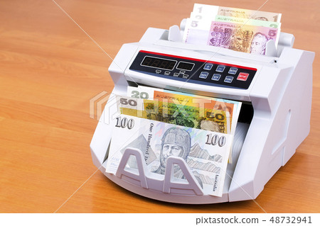Australian Dollars in a counting machine  48732941