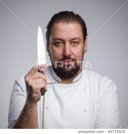 Cook holding a sharp knife. Cook holding a sharp knife. 48735928