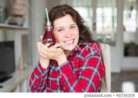 Detox, diet and healthy lifestyle concept - woman is showing cherry juice 48736359