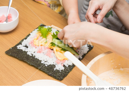 Making hand-rolled sushi 48736762